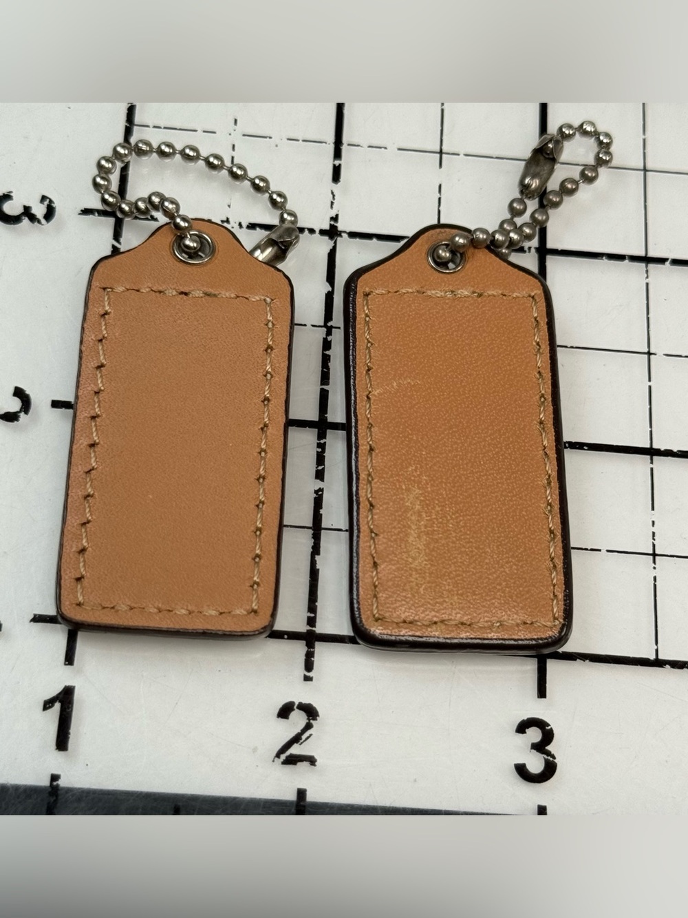 Coach two small Tan Leather Hang Tag Keychain Set. 2 by 1 inches. One with wear - Picture 3 of 5